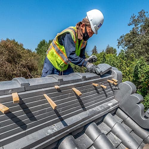 Japanese artisan Koji Ono places a roof tile on the Japanese Heritage House