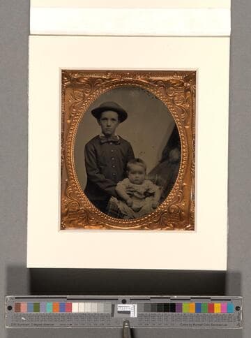 Portrait of a young boy holding a baby [Lathrop family]