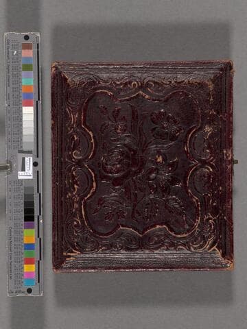 John B. Colton seated, wearing hat