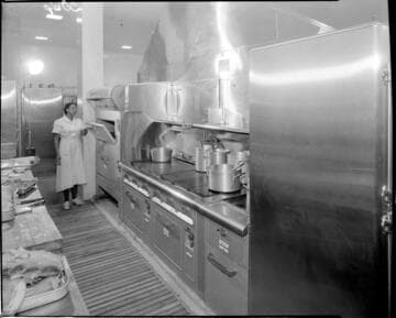 Chef peeking in oven in a commercial kitchen