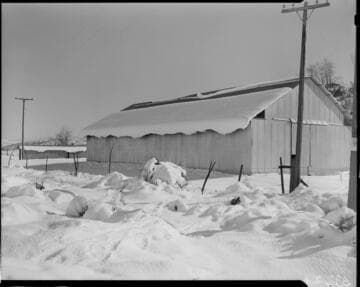 Metal building in desert covered in snow