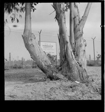 Sign for proposed Torrance Substation; men at their desks