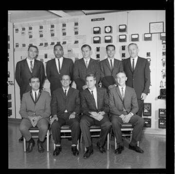 Nine men in a substation control room receiving certificates of completion for Edison's Substation Operators School