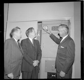 Installing meter and presenting All Electric Building plaque to owners of Hartman Noonan Professional Building