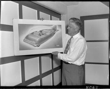 Man holding artist's rendering of 3 wheel automobile