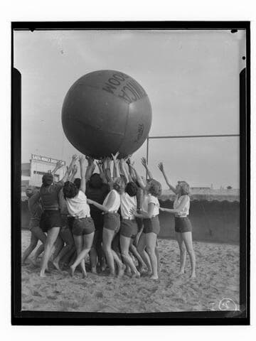 Women tossing giant La Monica Ballroom ball, Santa Monica