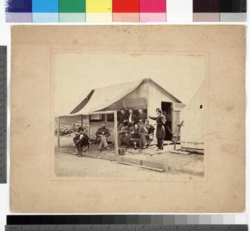 Group of Union soldiers in front of a small, open, wooden building