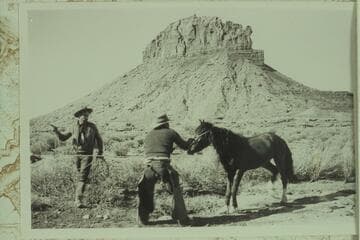 Wild Horse on a rope.  The butte behind the horse is Mt. Akaba.  The horse and man are south of Akaba looking north.  Photo 500 of Expedition to So-Called "Canyon of the Little Horses."
