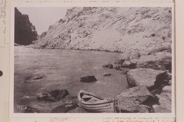 Brown-Stanton boat on the rocks at head of Rapid No. 23, Mile 202.20.  Caption reads:  No. 54.  Railway Survey, Colorado River, 1889.  Sta. 8735 UP.  46