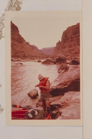 Bill Belknap adjusts life preserver up river from the rocks which trapped the Best Expedition Boat No. 1 on July 21, 1891