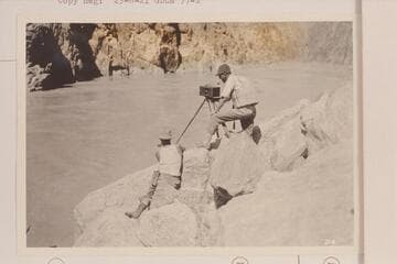 Moore and LaRue taking a panorama picture near the foot of Sockdologer Rapid.  Note the dangerous boots worn by Moore