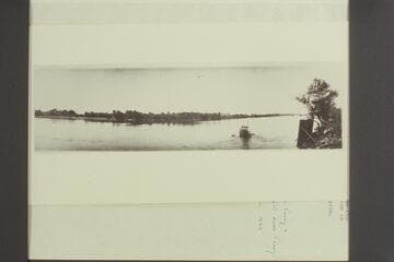 Skiff ferry carrying small buggy at Eherenberg [sic].  The makeshift oars are handled by an oarsman sitting under the buggy.  The regular scow used for ferrying is on its side at the right of the photo where its water-logged bottoom is drying
