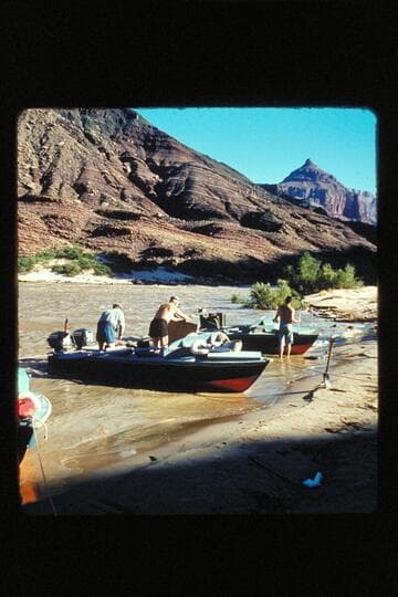Two boats beached below butte