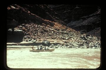 George Wing frees the Nevills San Juan punt from rock near Johns Canyon.  MH gauge:  1190 cfs