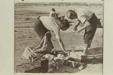 Anne Desloge and Zoe Desloge pack up at the camp at Pierces Ferry after the end of the 1947 Grand Canyon traverse.  Margaret Marston is in the background