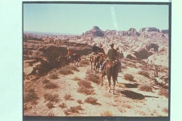 The party approaching ruined Rainbow Lodge after climbing out of Cliff Canyon.  Tom Daly sits on the horse nearest the camera.  Marston, Desloge and Atherton are right to left ahead of Tom.  Octogon Mesa is upper center