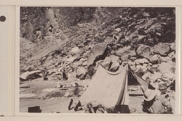 Eddy's boat "Powell" rolled on shore.  She capsized when being lined in Cataract Canyon at the head of The Big Drop.  Note food and clothing out to dry.  From Carey collection