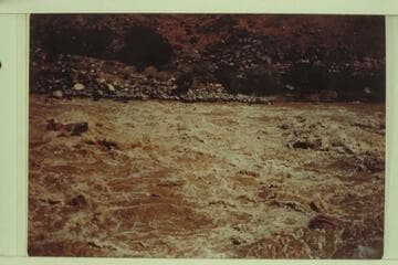 Motorboat just past the wave at the head of Lava Falls and cutting to the left to avoid the holes at the right of the picture.  Marston, Desloge, and Taylor in the boat