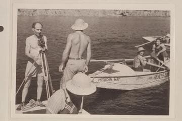 The first trip of Nevills through Grand Canyon; Lake Mead.  Emery Kolb at left; Elzada Clover, lower front; Lorin Bell at the oars of the "Mexican Hat"; Lois Jotter sits on stern