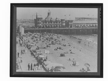 People on beach next to Looff Pleasure Pier and Santa Monica Pier