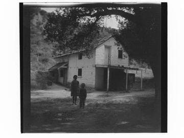 Two children standing in front of a house