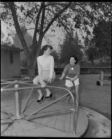 Two young lady in shorts, sweaters, and heals playing on a merry