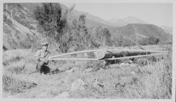 Series of 3 shots copied from a photo album page of men digging in rocky desert soil to place a power pole