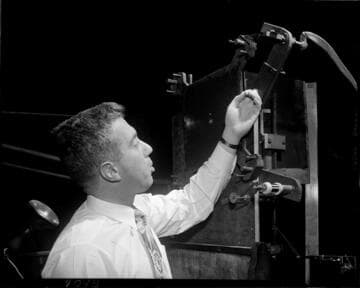 Man feeding a thin wire through a machine