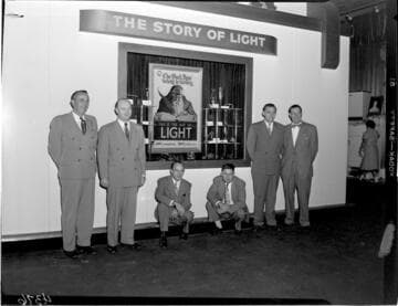 Edison display booth exhibiting the "Story of Light" with six men posed in the shot