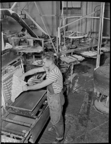 Man pulling material off mold