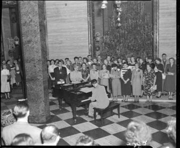 Edison chorus performing by Christmas tree in Edison General Office lobby