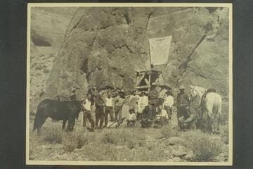 Party posed at the draped plaque at Rainbow Bridge