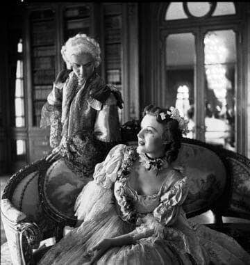 Couple in period costume on Louis XIV settee in the library of the Huntington residence