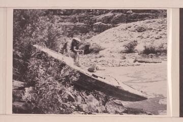 Tony Backus' boat the "Illinois Girl" on the rocks at the head of the Canyon of Lodore.  Buzz Homstrom looking into the cockpit