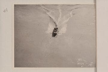 The "Esmeralda II" under the suspension bridge at Bright Angel Creek.  The water patterns illustrate the drag which kept the speed so low