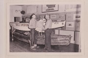 Pat Reilly presenting life-preserver to Park Supt. Harold C. Bryant at the Naturalists Workshop at the South Rim of Grand Canyon.Boats are the Galloway type "Glen" used by the USGS in its 1923 survey and the sadiron shaped Nevills type, the "Wen."