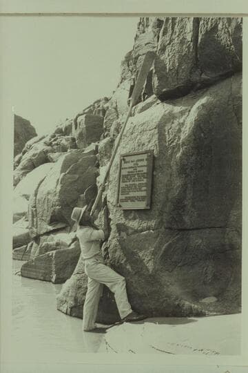 Harry Aleson reaching an oar so the tip of the blade was at the high level of the spring floods prior to the removal of the Separation Plaque to its present higher level