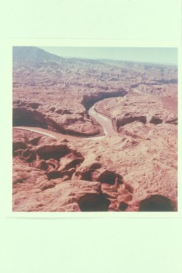 Down Glen Canyon from over Cottonwood Creek. Hidden Passage enters from right. Music Temple is just below and opposite. Anasazi Canyon enters from left above center. Navajo Mountain and Butte 6069 are upper left. Butte 5014 upper center